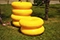 Das Bild zeigt sechs knallgelbe Schwimmringe aufgestapelt auf einer Wiese.